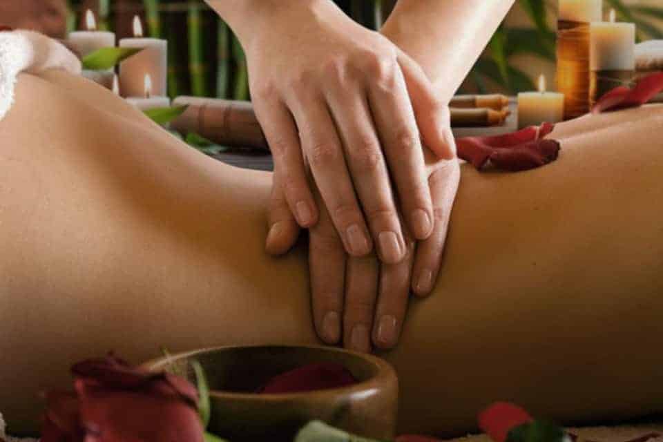 Masaje relajante con velas y pétalos de rosa.